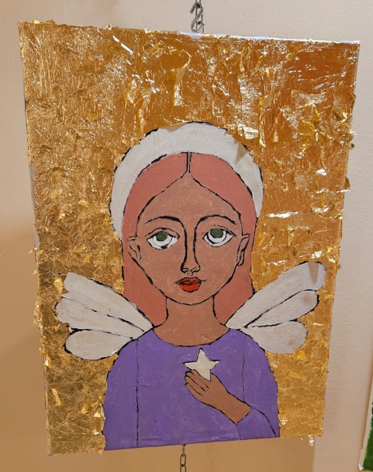 Na zdjęciu widać obraz będący portretem kobiety ze skrzydłami trzymającej w ręce gwiazdę , tło jest złote.