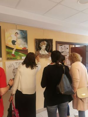 Uczestnicy oglądający prace malarskie prezentowane na wernisazu wystawy "to co kocham"