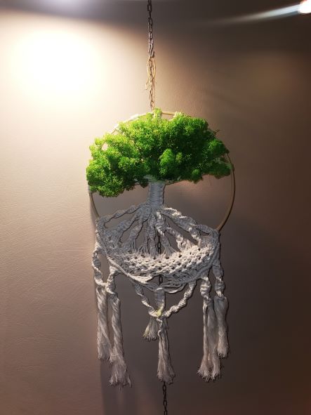 Na zdjęciu widać makramę w kształcie drzewa, z koroną przyozdobioną zielonym mchem.